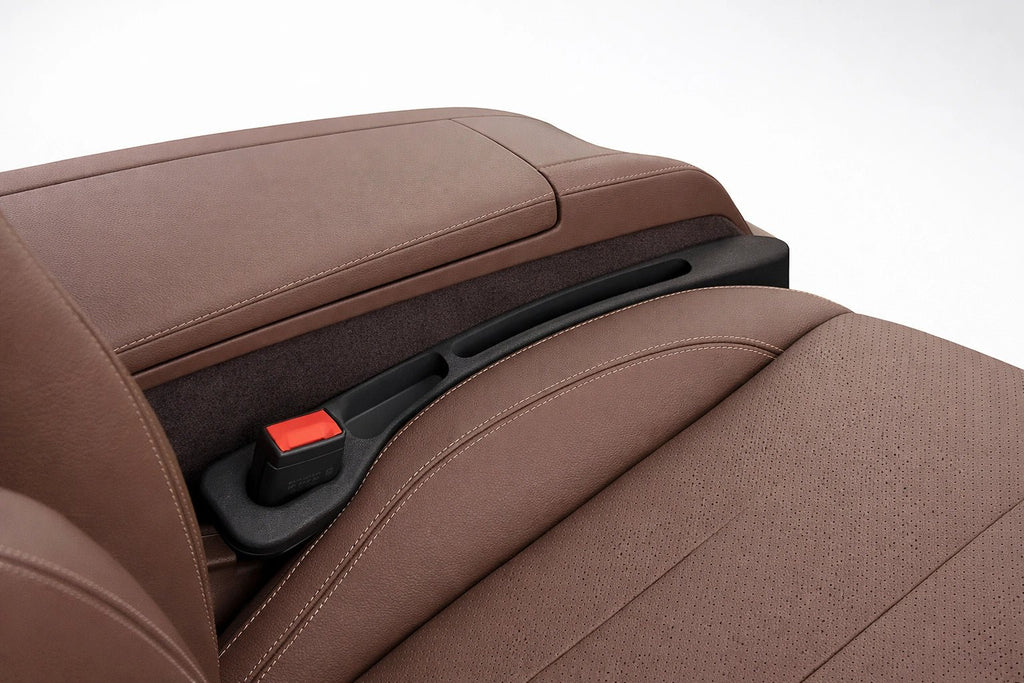 Black car seat gap filler installed between seat and console to prevent items from falling and provide extra storage.
